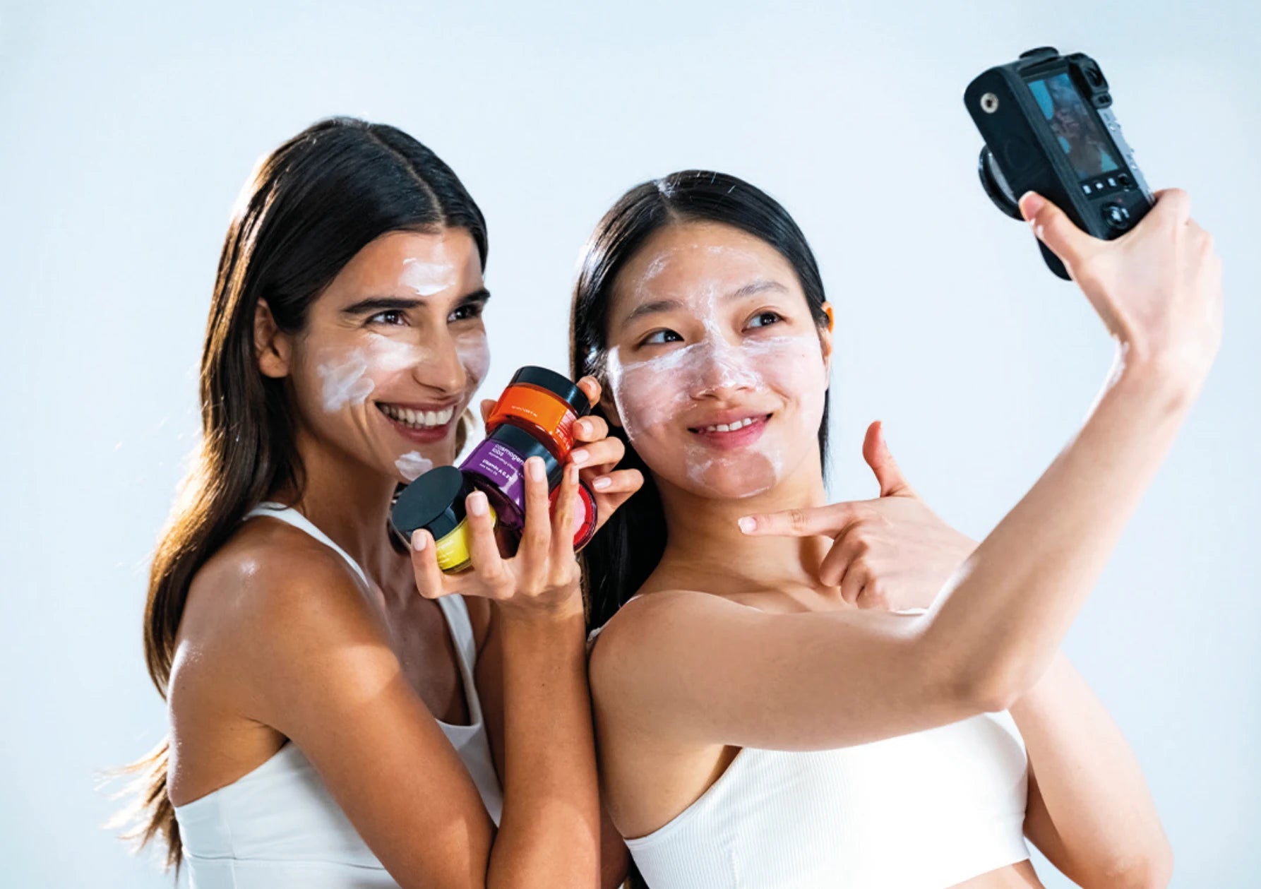 Two women sharing a skincare moment with Cosmogenesis Labs products